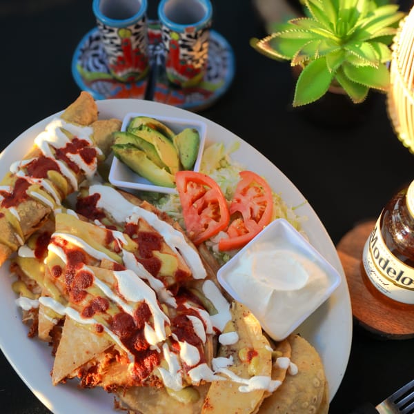 Mi Pueblito Cafe's nachos with avocado, tomatoes, sour cream, and a Modelo beer.